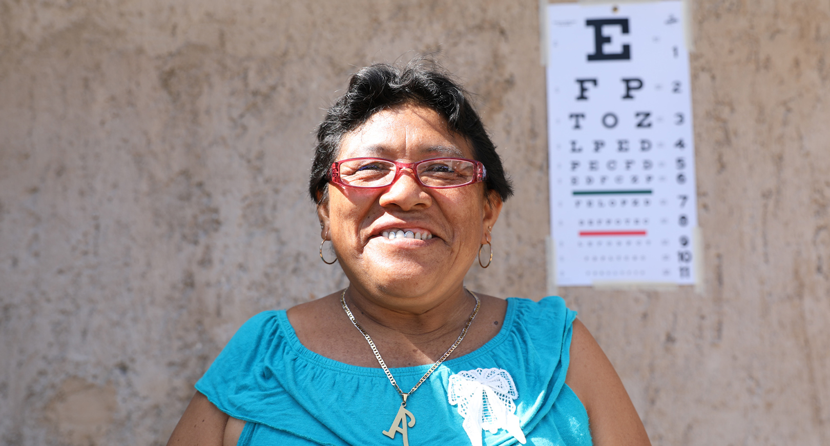laughing woman standing in front of eye chart